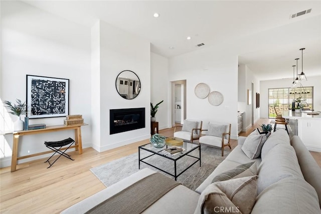 4140 Hillside Dr, San Luis Obispo, CA 93401 - living room with light wood-type flooring, recessed lighting, a glass covered fireplace, and baseboards