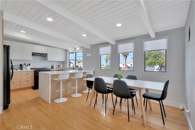 120 Avenida Santa Margarita, San Clemente, CA 92672 - kitchen with gas stove, freestanding refrigerator, under cabinet range hood, a kitchen bar, and light wood-type flooring