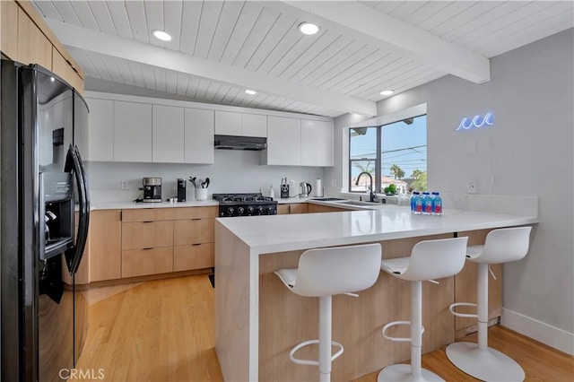 120 Avenida Santa Margarita, San Clemente, CA 92672 - kitchen with black fridge, a sink, light wood-style floors, a peninsula, and beam ceiling