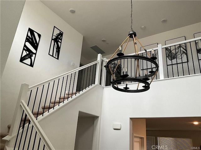 staircase featuring a chandelier and a high ceiling