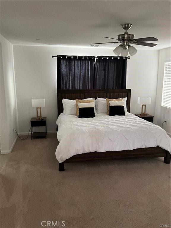 carpeted bedroom featuring baseboards and a ceiling fan