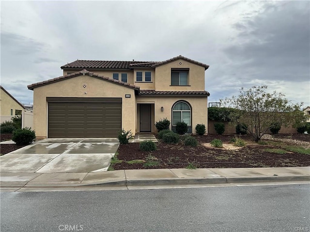 view of front of home featuring an attached garage, stucco siding, driveway, and a tiled roof