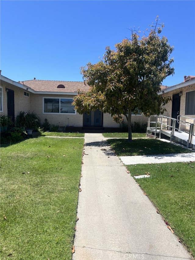 view of front facade with a front yard and stucco siding