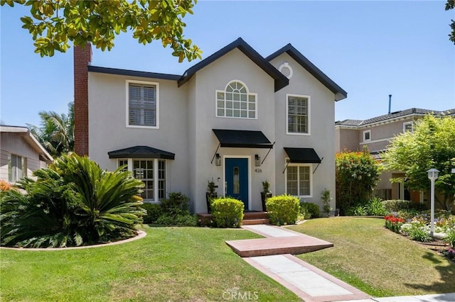 426 Ultimo Ave, Long Beach, CA 90814 - traditional-style home with stucco siding, a chimney, and a front lawn