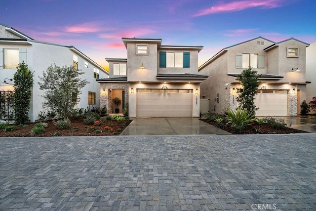 16225 Orizaba Ave, Paramount, CA 90723 - view of front of home featuring decorative driveway, a garage, stucco siding, and stone siding