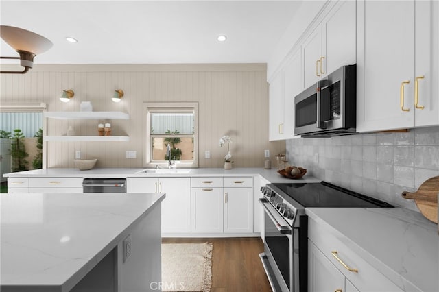 16225 Orizaba Ave, Paramount, CA 90723 - kitchen with appliances with stainless steel finishes, a sink, white cabinets, wood finished floors, and tasteful backsplash
