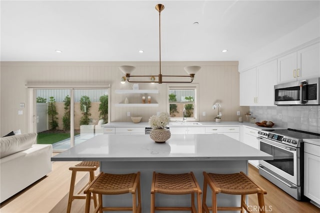 16225 Orizaba Ave, Paramount, CA 90723 - kitchen with appliances with stainless steel finishes, light wood-style floors, plenty of natural light, a kitchen breakfast bar, and recessed lighting