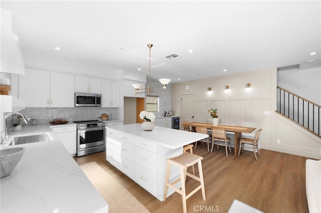 16225 Orizaba Ave, Paramount, CA 90723 - kitchen with stainless steel appliances, a sink, decorative backsplash, white cabinets, and recessed lighting