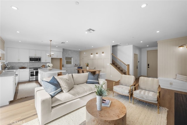 16225 Orizaba Ave, Paramount, CA 90723 - living room with stairs, light wood-type flooring, recessed lighting, and a decorative wall