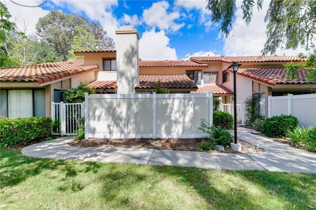 1327 Solera Ln Unit 6, Diamond Bar, CA 91765 - view of front facade with a chimney, fence, stucco siding, and a tile roof