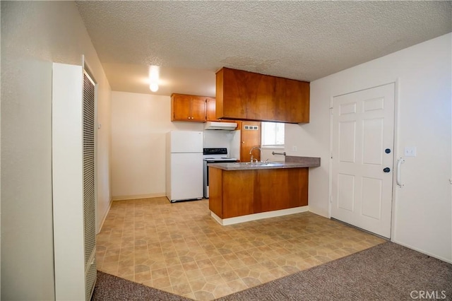 1905 Normal Ave, Chico, CA 95928 - kitchen featuring freestanding refrigerator, range with electric stovetop, a peninsula, under cabinet range hood, and brown cabinetry