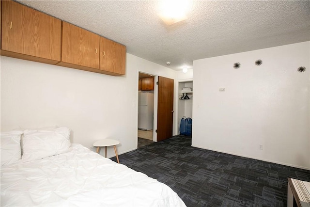 1905 Normal Ave, Chico, CA 95928 - bedroom featuring freestanding refrigerator, dark carpet, a textured ceiling, and a closet