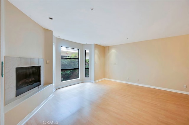 1161 Spazier Ave Unit 4, Glendale, CA 91201 - unfurnished living room featuring light wood finished floors, a tiled fireplace, baseboards, and recessed lighting