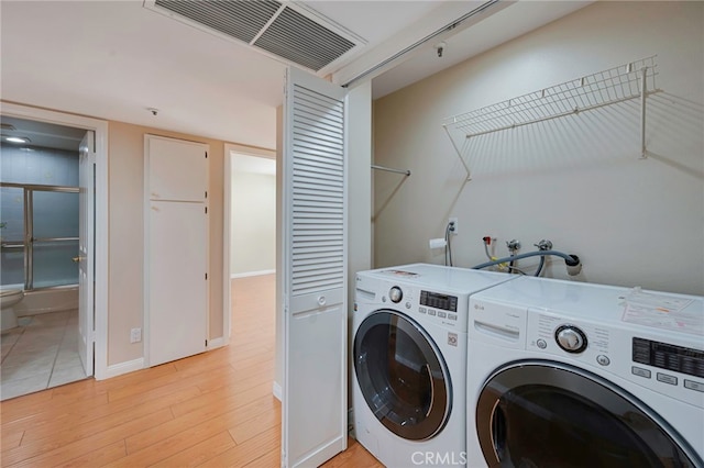 1161 Spazier Ave Unit 4, Glendale, CA 91201 - laundry room featuring washing machine and clothes dryer, light wood-style flooring, and baseboards