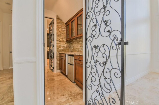 12932 Carnesi Dr, Rancho Cucamonga, CA 91739 - bar area featuring refrigerator, light marble finish flooring, and backsplash