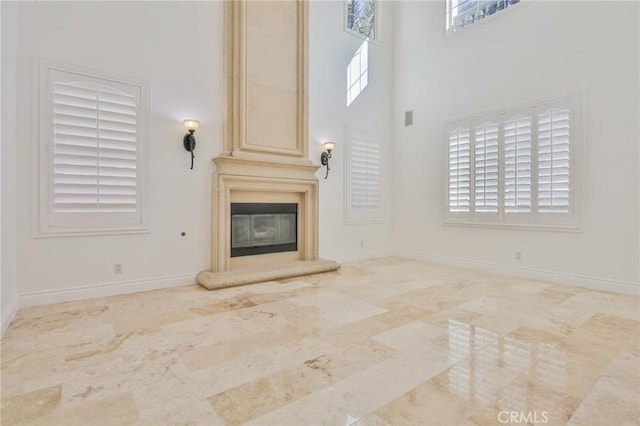 12932 Carnesi Dr, Rancho Cucamonga, CA 91739 - unfurnished living room featuring baseboards, a towering ceiling, and a large fireplace