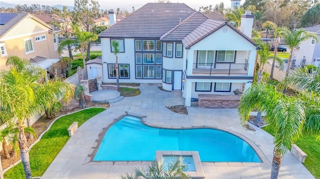 12932 Carnesi Dr, Rancho Cucamonga, CA 91739 - rear view of property featuring a balcony, a chimney, a patio, a fenced backyard, and a tiled roof
