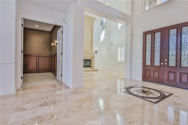 12932 Carnesi Dr, Rancho Cucamonga, CA 91739 - foyer entrance featuring marble tiled floors, baseboards, a glass covered fireplace, and a towering ceiling