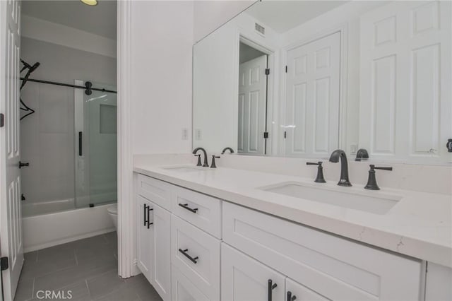 12932 Carnesi Dr, Rancho Cucamonga, CA 91739 - bathroom featuring tile patterned flooring, double vanity, enclosed tub / shower combo, and toilet