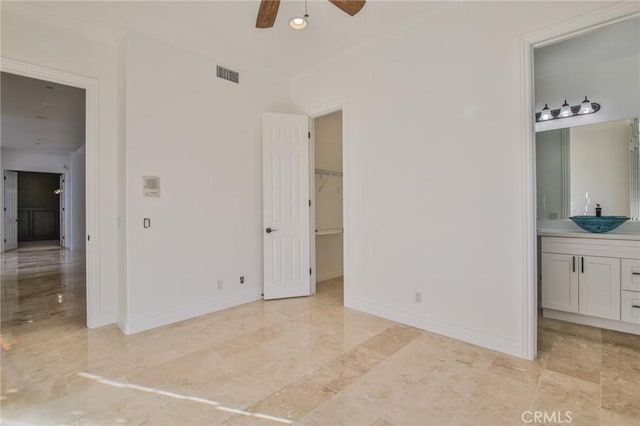 12932 Carnesi Dr, Rancho Cucamonga, CA 91739 - unfurnished bedroom with a sink, ensuite bath, a walk in closet, baseboards, and ornamental molding