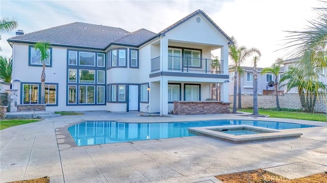 12932 Carnesi Dr, Rancho Cucamonga, CA 91739 - back of property featuring a balcony, stucco siding, an in-ground hot tub, and a patio area