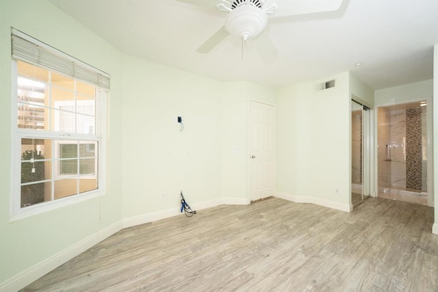 spare room with light wood-type flooring, baseboards, and a ceiling fan
