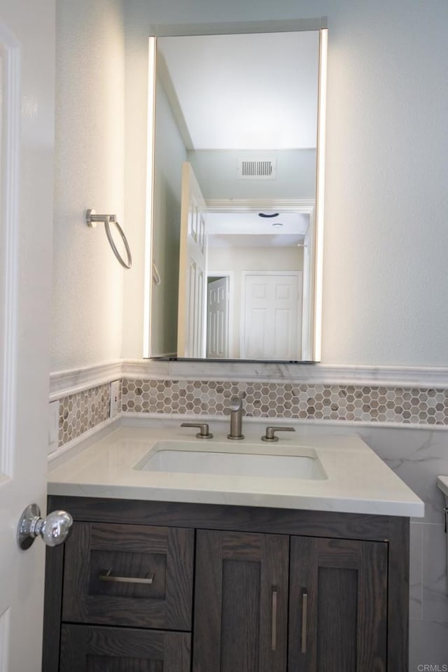 bathroom featuring vanity and tile walls