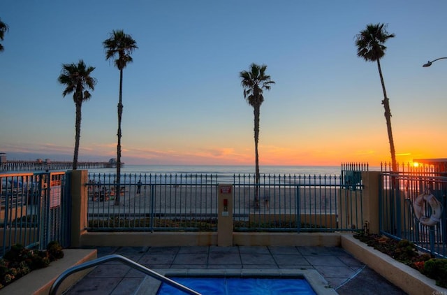 view of swimming pool with a water view and fence