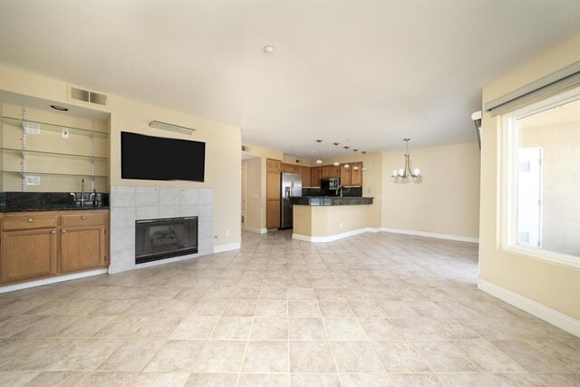 unfurnished living room with a fireplace, a chandelier, baseboards, and recessed lighting