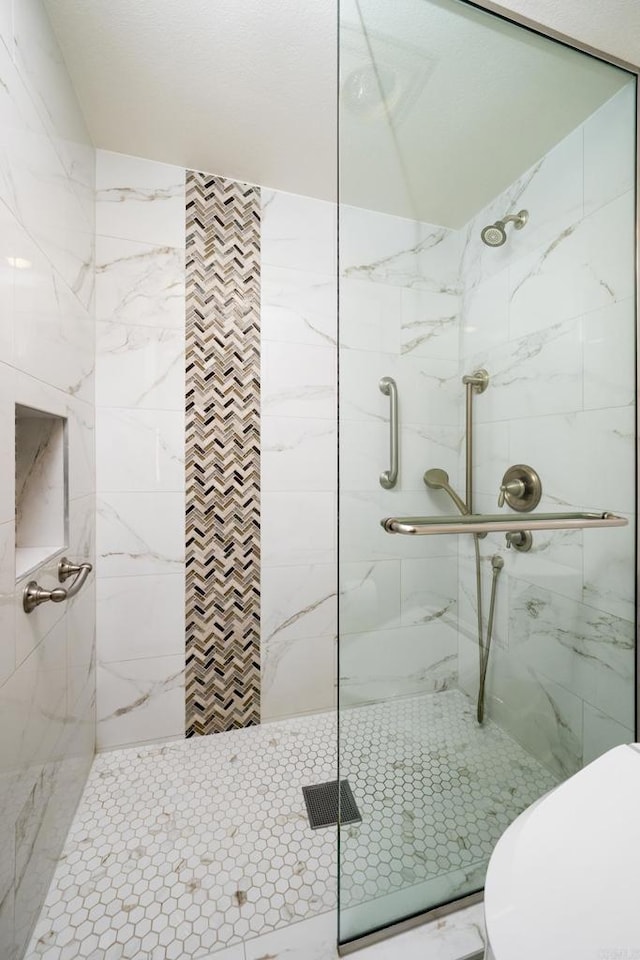 full bathroom featuring a marble finish shower and toilet