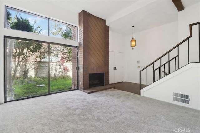 4515 Alla Rd Unit 2, Marina Del Rey, CA 90292 - unfurnished living room featuring a towering ceiling, carpet floors, stairs, and a brick fireplace