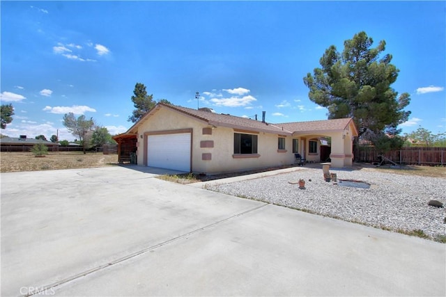 ranch-style house with an attached garage, fence, stucco siding, and concrete driveway