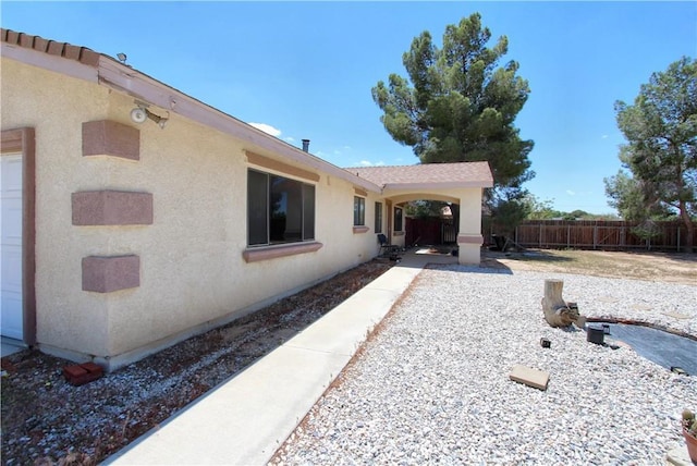 back of house featuring fence and stucco siding