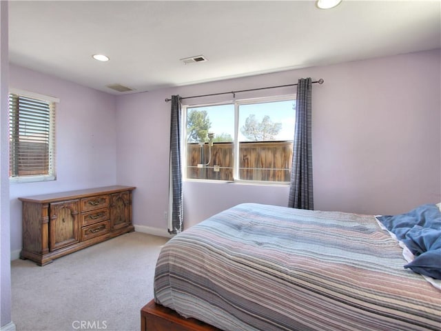 bedroom with multiple windows, light carpet, recessed lighting, and baseboards
