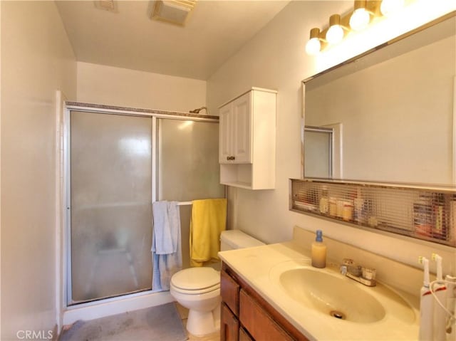 full bathroom featuring a shower stall, toilet, and vanity