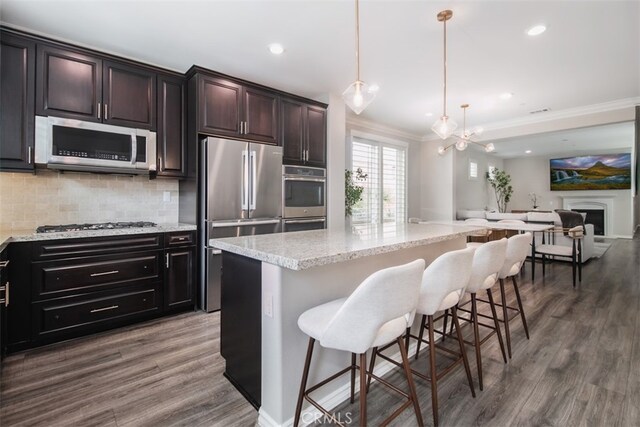 29048 N W Hills Dr, Valencia, CA 91354 - kitchen with appliances with stainless steel finishes, ornamental molding, decorative backsplash, open floor plan, and wood finished floors