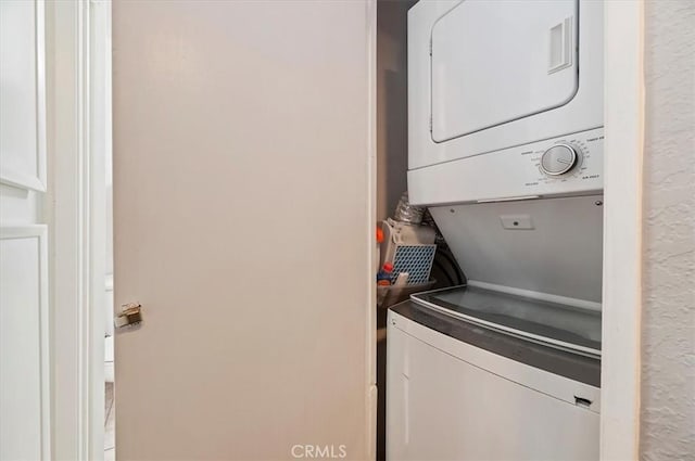 laundry room featuring stacked washer / drying machine