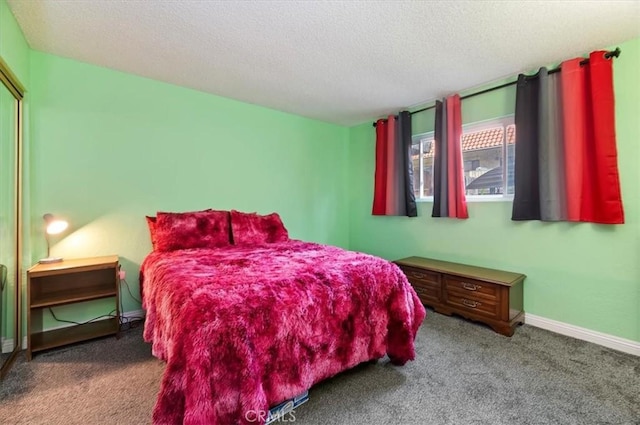 carpeted bedroom with a textured ceiling and baseboards