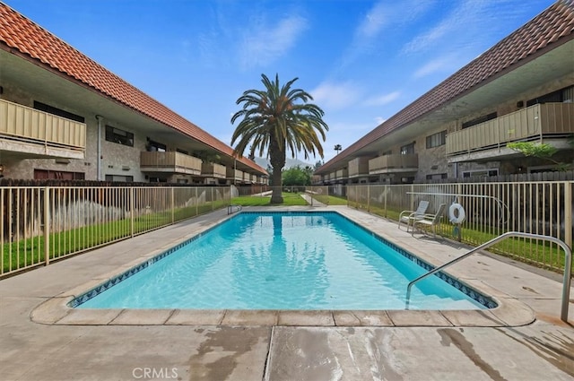 community pool featuring fence and a patio