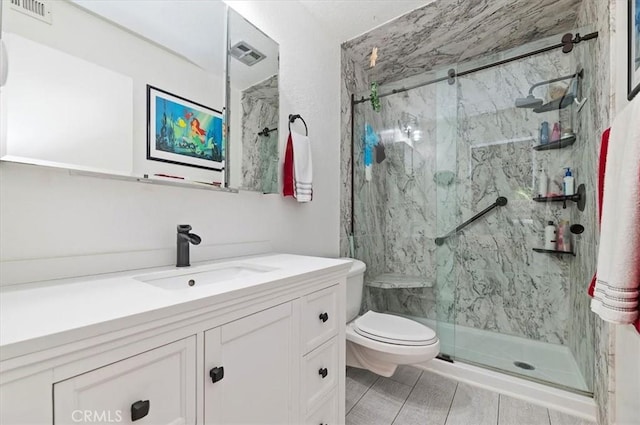 bathroom with a marble finish shower, toilet, and vanity