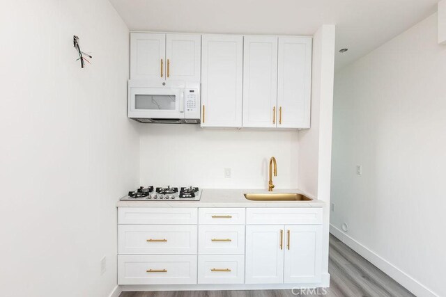 4401 La Clede Ave, Los Angeles, CA 90039 - kitchen featuring white appliances, a sink, light wood-style floors, white cabinetry, and light countertops