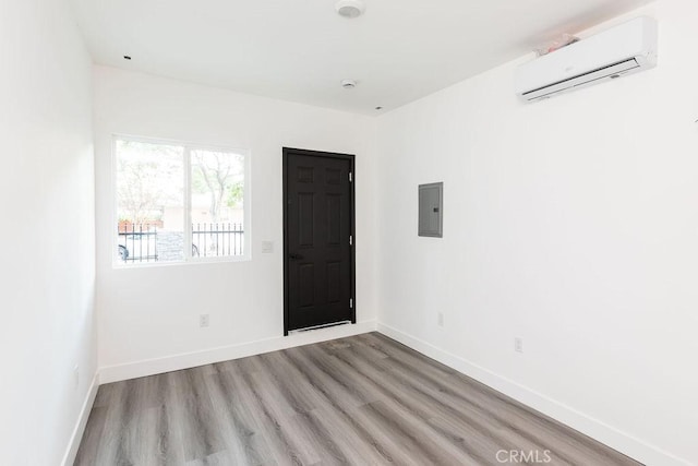 4401 La Clede Ave, Los Angeles, CA 90039 - unfurnished room featuring a wall mounted air conditioner, electric panel, wood finished floors, and baseboards