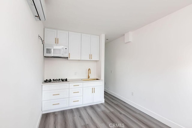 4401 La Clede Ave, Los Angeles, CA 90039 - kitchen featuring white microwave, baseboards, light wood-type flooring, and white cabinetry