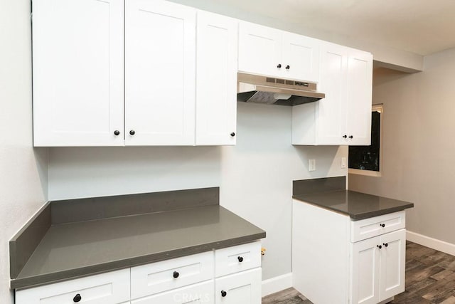 4401 La Clede Ave, Los Angeles, CA 90039 - kitchen with under cabinet range hood, dark wood-style floors, dark countertops, baseboards, and white cabinetry