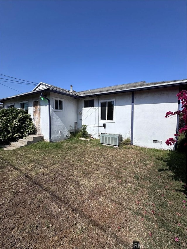 15407 S Visalia Ave, Compton, CA 90220 - back of house featuring stucco siding, central air condition unit, and a lawn