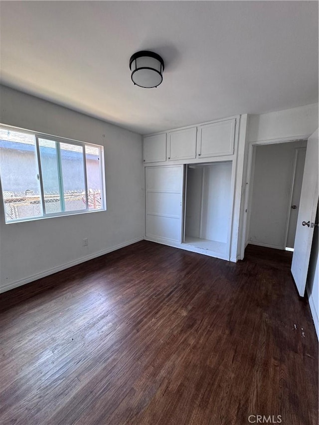 15407 S Visalia Ave, Compton, CA 90220 - unfurnished bedroom featuring dark wood-style floors, baseboards, and a closet