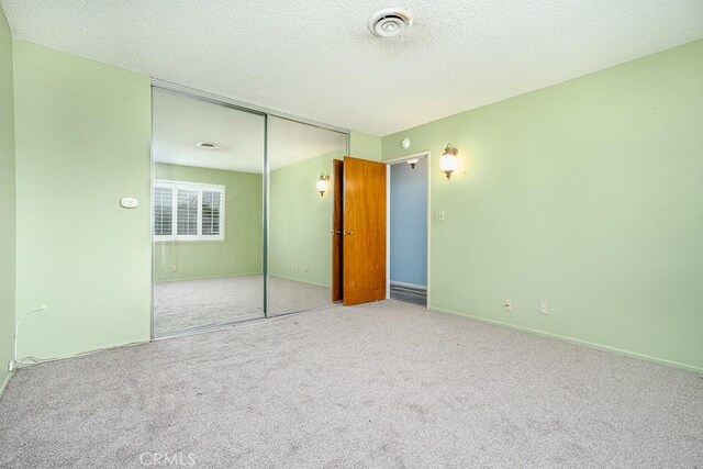 43451 Briercliff Dr, Hemet, CA 92544 - unfurnished bedroom featuring carpet flooring, a closet, a textured ceiling, and baseboards