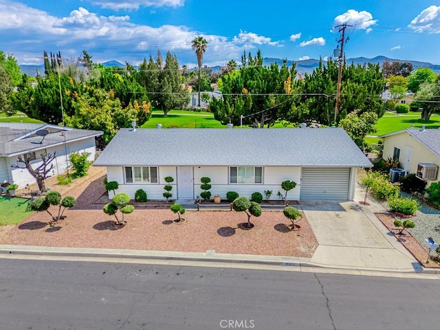 43451 Briercliff Dr, Hemet, CA 92544 - view of front of house featuring concrete driveway, an attached garage, central AC unit, a mountain view, and a shingled roof
