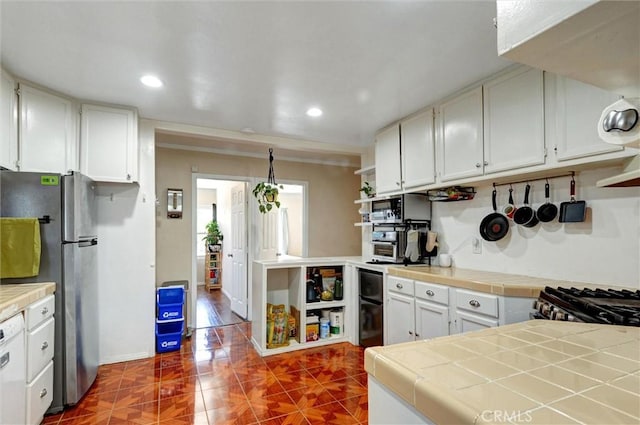 5864 Bonsallo Ave, Los Angeles, CA 90044 - kitchen featuring appliances with stainless steel finishes, tile counters, dark tile patterned floors, recessed lighting, and white cabinets
