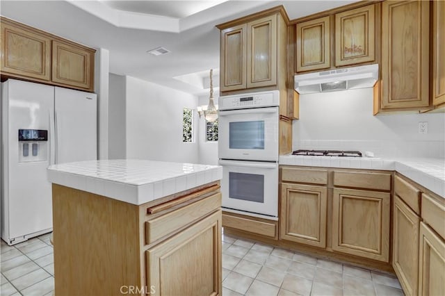 4064 Lemonberry Pl, Thousand Oaks, CA 91362 - kitchen featuring white appliances, a raised ceiling, tile countertops, and under cabinet range hood